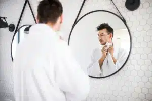 Man looking in the mirror following a Botox Treatment
